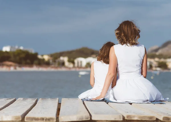 Donna e bambino seduti sul molo . — Foto Stock