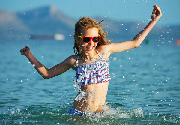 Lilla flickan har roligt i havet. — Stockfoto