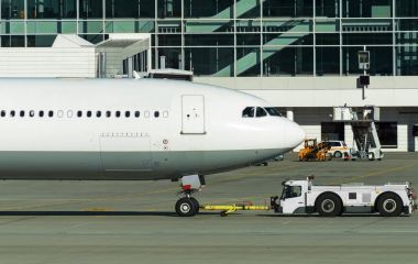 Römorkör Pushback traktör Havaalanı pist üzerinde uçak ile.