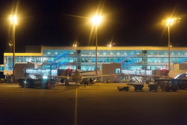 Passagierflugzeug und Busse am Nachtflughafen. — Stockfoto