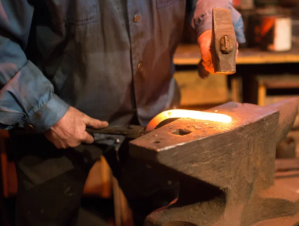 Maken van hoefijzer. Mannelijke werknemer met Tang en hamer maken hoefijzer. — Stockfoto