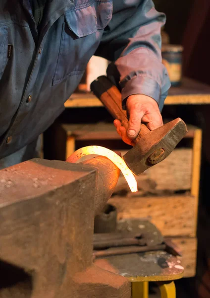 Maken van hoefijzer. Mannelijke werknemer met Tang en hamer maken hoefijzer. — Stockfoto