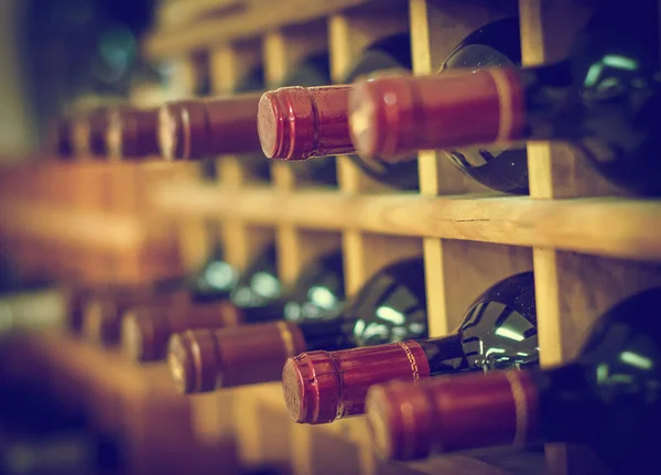 Rotweinflaschen auf Holzregalen gestapelt — Stockfoto