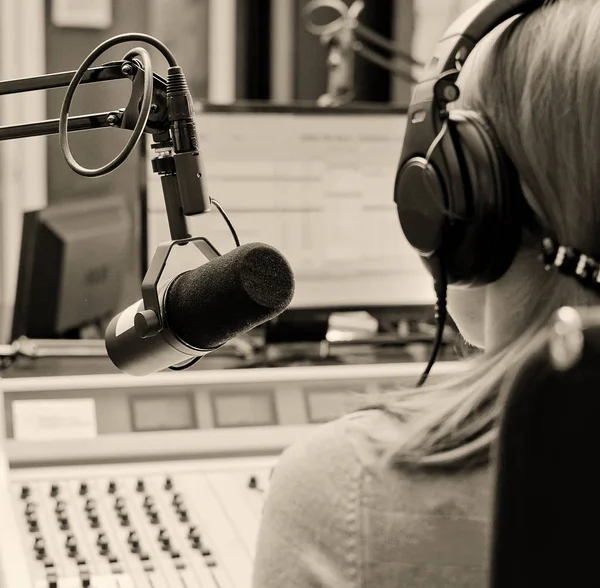 Arkadan görünüş kadın DJ r üzerinde bir mikrofon önünde çalışma — Stok fotoğraf