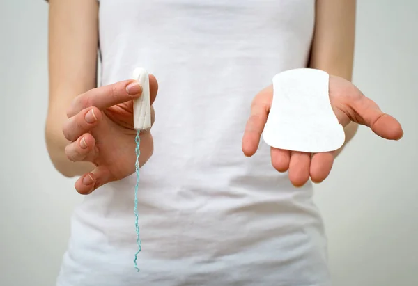 Žena držící menstruační vložka a tampon v dlaních. — Stock fotografie