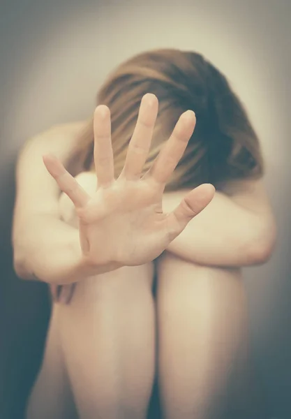 Scared woman sitting in the corner. — Stock Photo, Image