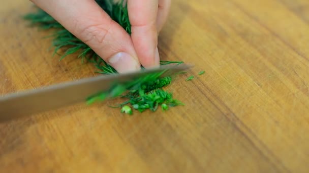 Frau mit Messer schneidet Dill in Küche. — Stockvideo