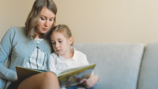 Mor och dotter läser en bok. — Stockvideo
