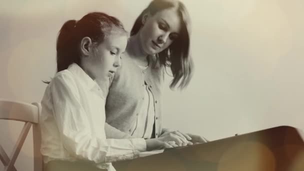 Жінка навчає маленьку дівчинку грати на піаніно . — стокове відео