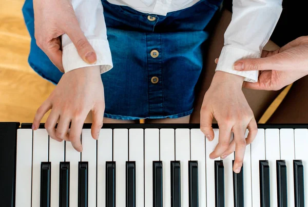 Woman teaching little girl to play the piano. Top view. — Stock Photo, Image