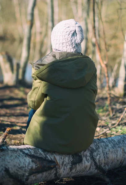 Μικρό κορίτσι που κάθεται σε ένα ημερολόγιο στο δάσος. — Φωτογραφία Αρχείου