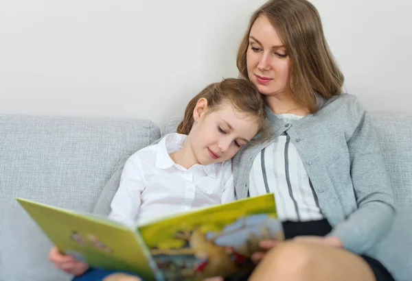 Anne ve kızı kitap okuyorlar.. — Stok fotoğraf