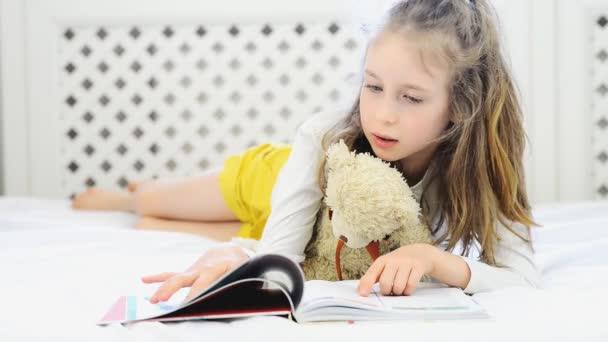 Niña leyendo libro con su amigo de peluche . — Vídeos de Stock