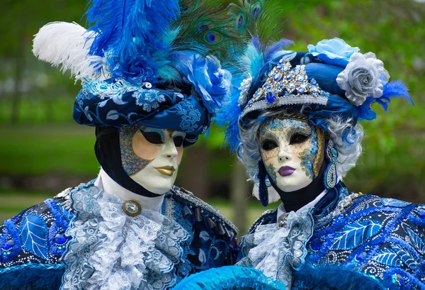 Unerkennbare Menschen in venezianischen Masken beim Straßenkarneval. — Stockfoto