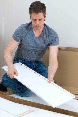 Evde mobilya montajı yapan yakışıklı adam..