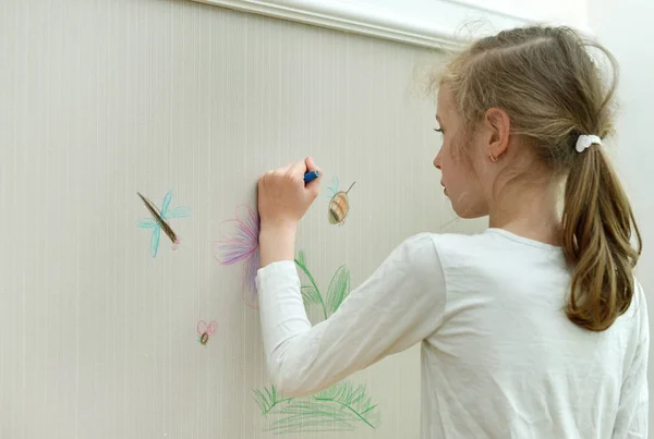 Little girl drawing on the wallpaper with pencil. — Stock Photo, Image