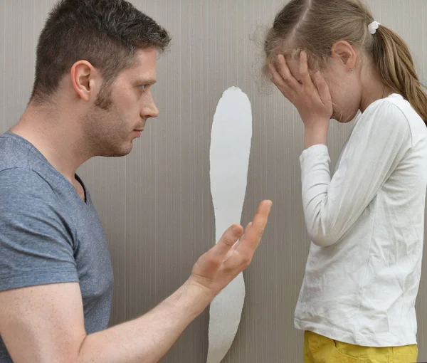Little girl spoiled the wallpaper and her dad is angry. — Stock Photo, Image