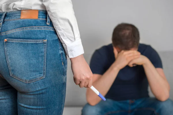Girl with pregnancy test in front of sad boyfriend. — Stock Photo, Image