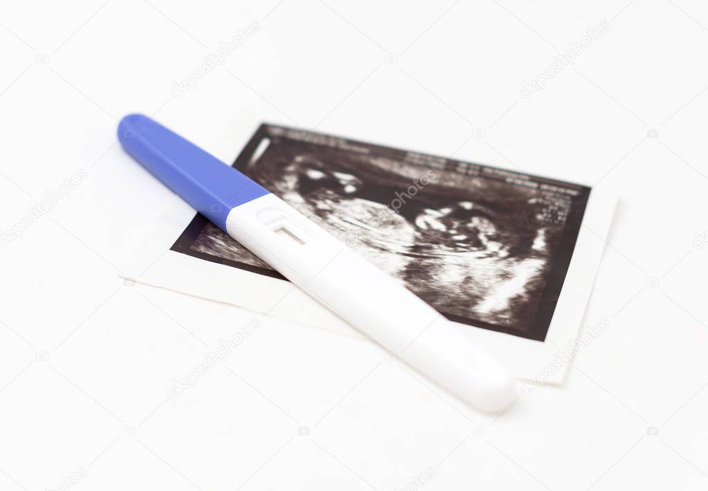 Plastic pregnancy test and ultrasound picture.