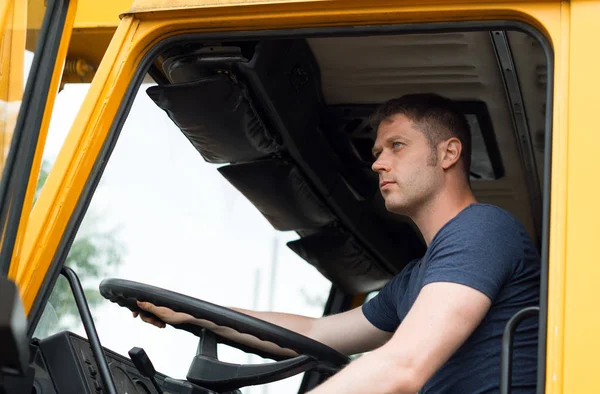 Manliga trucker i stuga på sin gula bil. — Stockfoto