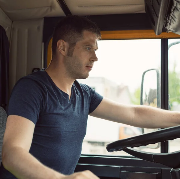 Camionista masculino na cabine de seu caminhão amarelo . — Fotografia de Stock