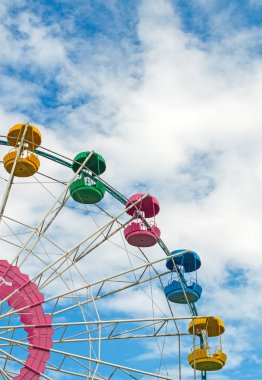 Renkli dönme dolap üzerinde mavi gökyüzü.