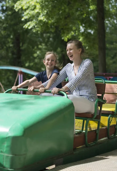 Dziewczynka i jej matka, zabawy na roller coaster. — Zdjęcie stockowe