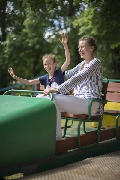 Kleines Mädchen und ihre Mutter amüsieren sich auf Achterbahn. — Stockfoto