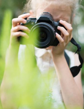 Sevimli küçük kız doğa fotoğraflarını yapıyor.