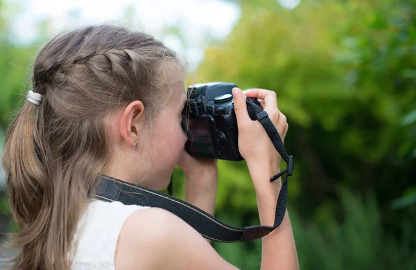 Sevimli küçük kız doğa fotoğraflarını yapıyor.