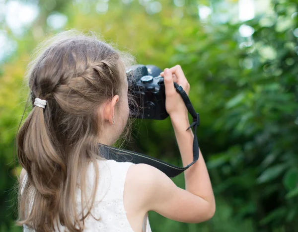 Sevimli küçük kız doğa fotoğraflarını yapıyor.