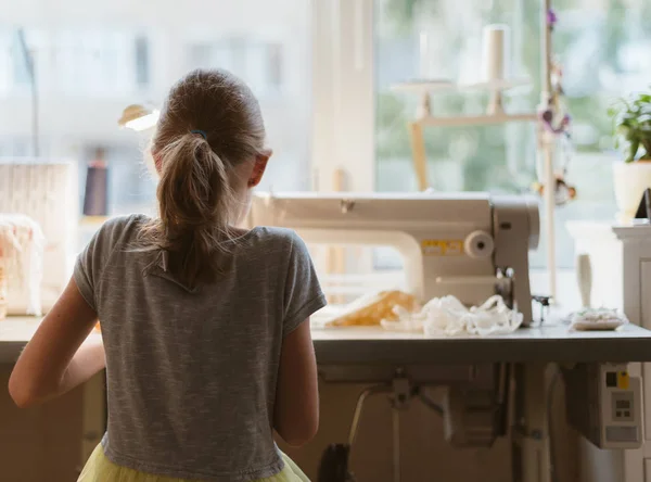 Kleines Mädchen arbeitet zu Hause an Nähmaschine. — Stockfoto