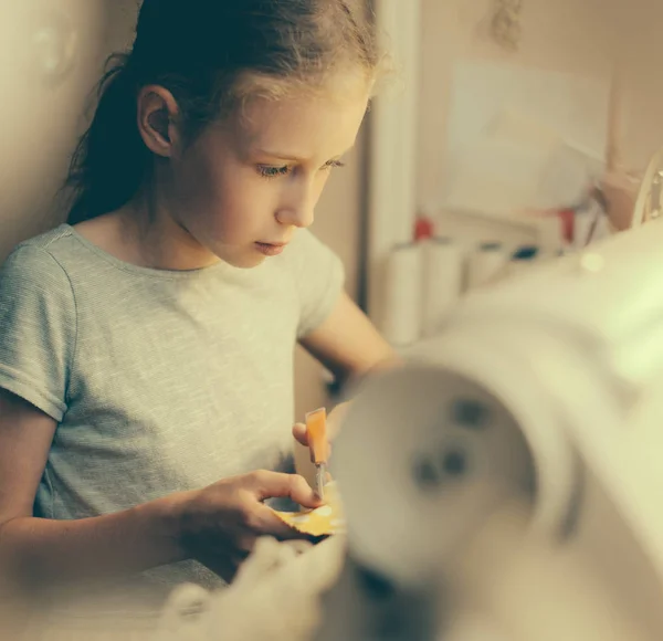 Menina trabalhando na máquina de costura em casa . — Fotografia de Stock