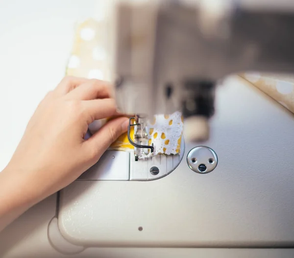 Little girl working on sewing machine at home. Close-up view. — Stock Photo, Image