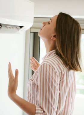 Isı ayakta Klima önünde gelen kadın.