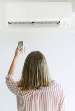 Uzaktan kumanda Klima havalandırma amaçlı tutan kadın.