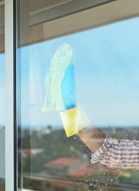 Ev temizliği. Kadın balkonda cam silme.