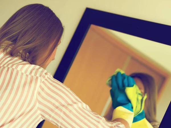 House cleaning. Woman is wiping mirror in the room. — Stock Photo, Image
