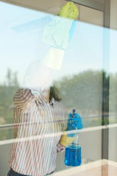 Limpieza de casas. Mujer está limpiando vidrio en el balcón . —  Fotos de Stock