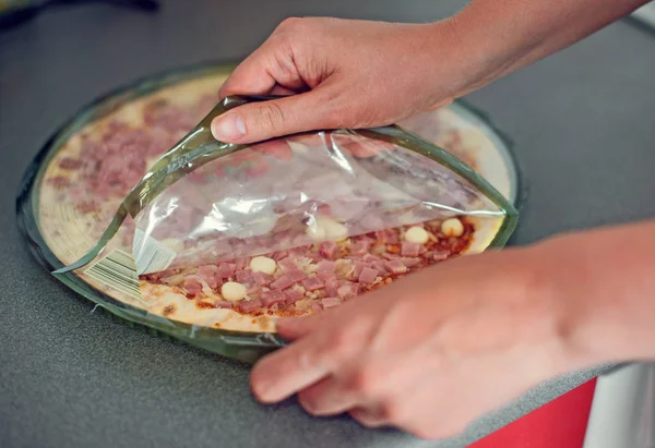 Mujer abriendo pizza comprada en una tienda . — Foto de Stock