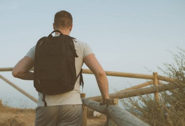 Sırt çantası olan adam tepeye yükselir.