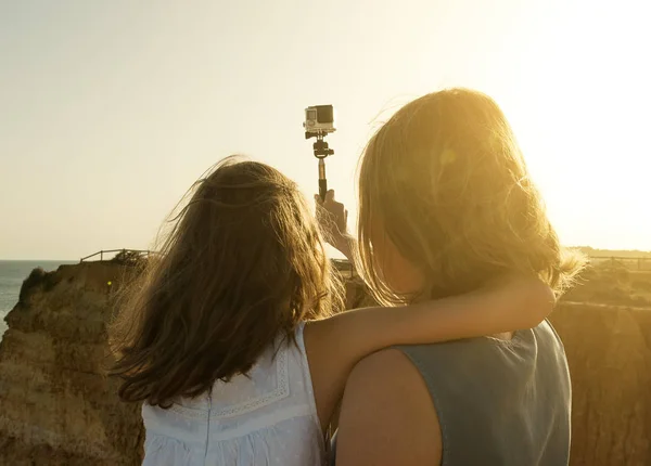 Frau und Tochter machen Selfie bei Sonnenuntergang. — Stockfoto