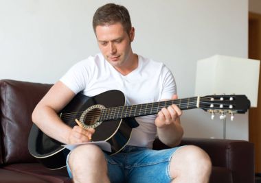 Yakışıklı adam oluşturmak bir şarkı gitar.