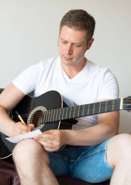 Yakışıklı adam oluşturmak bir şarkı gitar.