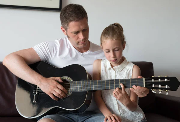 Pappa lär dotter att spela gitarr. — Stockfoto