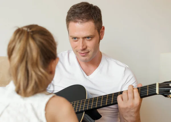 爸爸为他的女儿弹吉他. — 图库照片