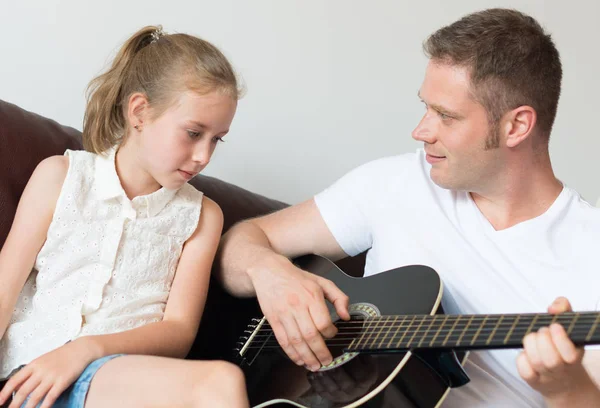 お父さんは彼の娘のギターを弾く. — ストック写真