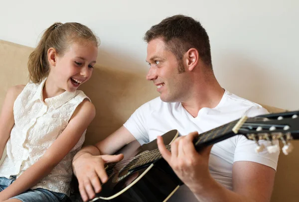 Dad plays the guitar for his daughter. — Stock Photo, Image