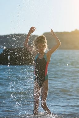 Küçük kız denizde eğleniyor.