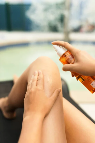 Woman applying sunblock cream on her legs. — Stock Photo, Image